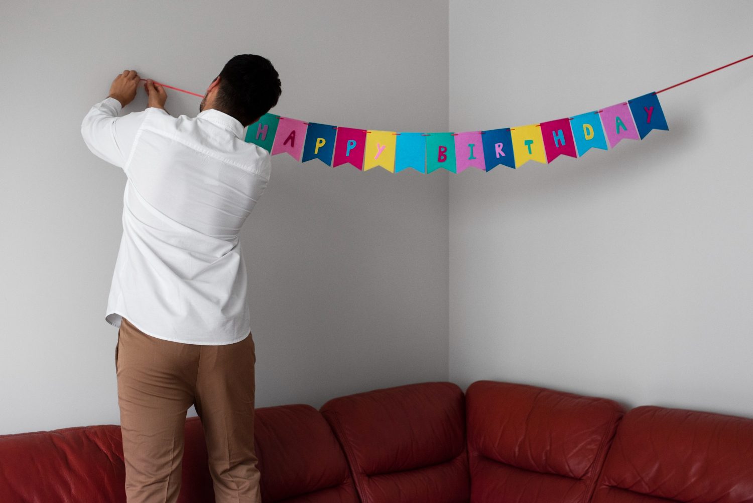 homem pendurando bandeirinhas para festa